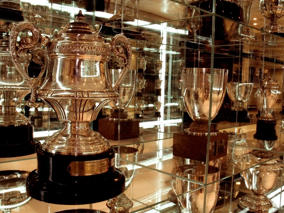 Close up of prestigious football trophies in a glass cabinet.