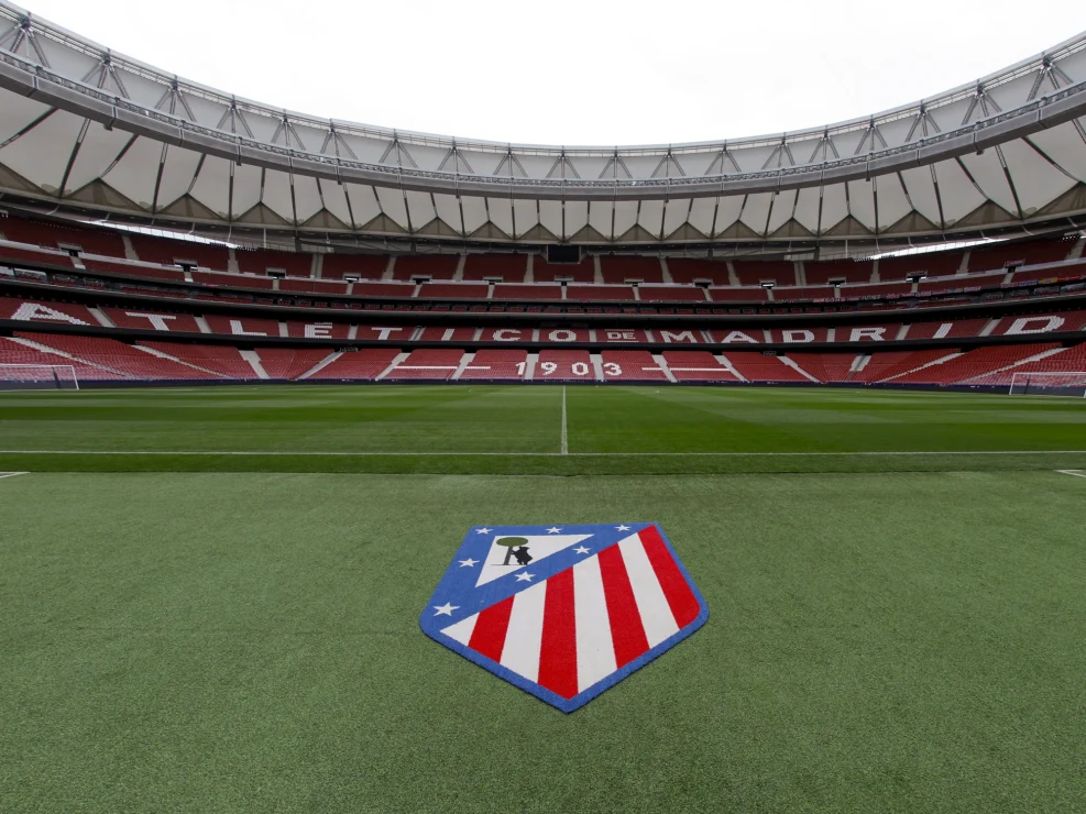 Atletico de Madrid stadium with logo on pitch.