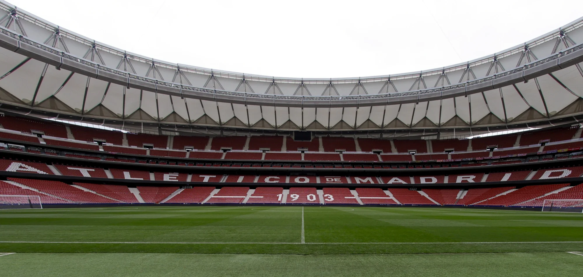 Atletico de Madrid stadium with logo on pitch.